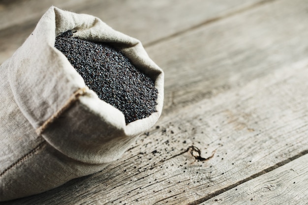 Poppy seeds in a burlap bag. The tasty and useful seeds rich with protein and oils.