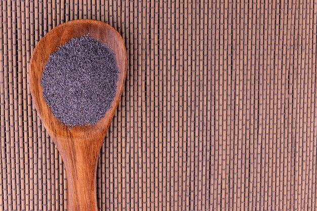 Poppy seeds in a wooden spoon Copy space