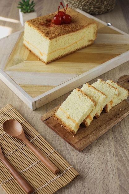 Populair Japans dessert of biscuitgebak van castella met kers op de top geserveerd op een houten tafel