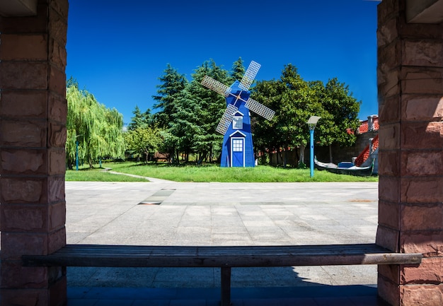 Popular city park Wallanlagen with Am Wall Windmill and colorful flowers foreground in Bremen, Germany