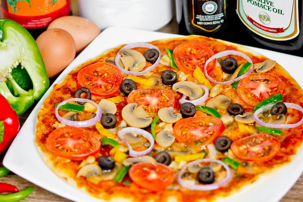 Popular colorful ingredients as like tomatoes cheese mushroom capsicum olives and other ingredients baked healthy pizza