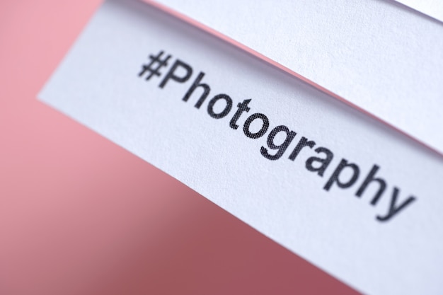 ピンクの白い紙に印刷された人気のハッシュタグ「写真」