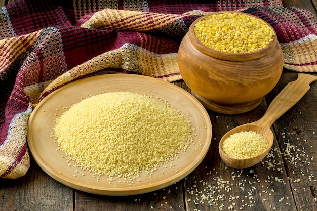 Popular ingredients oriental cuisine bulgur and couscous in wooden pot plate and spoon