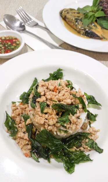 Cibo tailandese popolare, foglie di basilico fritte con pollo e riso al vapore