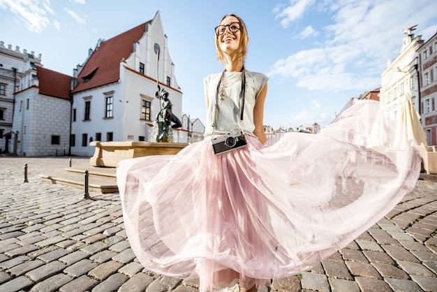 Porait of a young woman tourist traveling on the old Market sqaure in Poznan city during the morning light in Poland