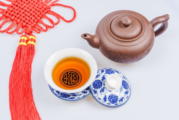 Porcelain teapot and teacup on white background