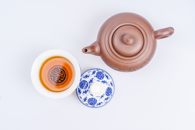 Porcelain teapot and teacup on white background