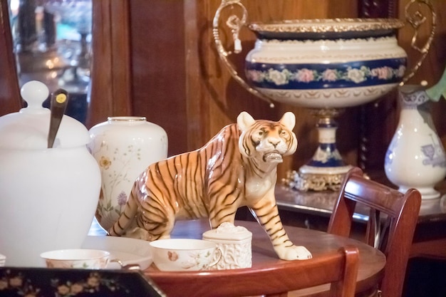 Фарфоровый тигр и посуда на столе