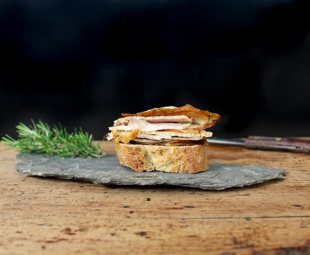 Foto porchetta crostini canape traditioneel vlees van de italiaanse keuken en gastronomie op een leisteenplaat