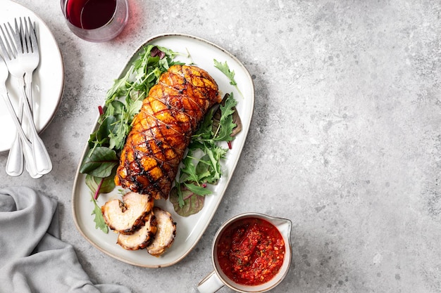 Porchetta un delizioso arrosto di maiale avvolto in un rotolo piatto tradizionale italiano per le vacanze su sfondo grigio cemento