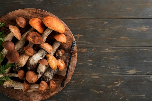 Porcini mushroom or mushroom an orangecap boletus on old dark rustic wooden table backgrounds Organic forest food Autumn harvest concept Edible fresh picked mushroom Copy space Top view