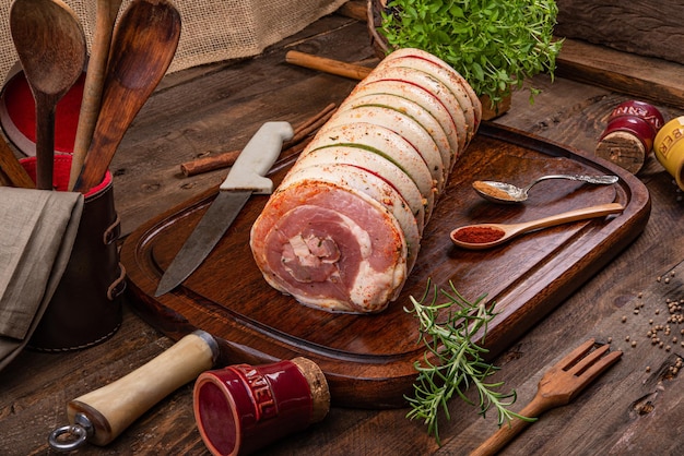 Pork belly rolled over wooden board and spices