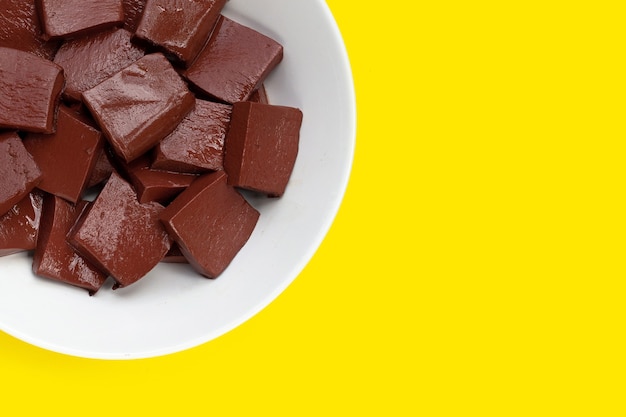 Pork blood pudding in white plate on yellow background.