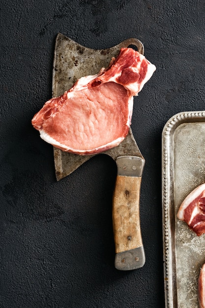 Pork bone butcher knife black background top view