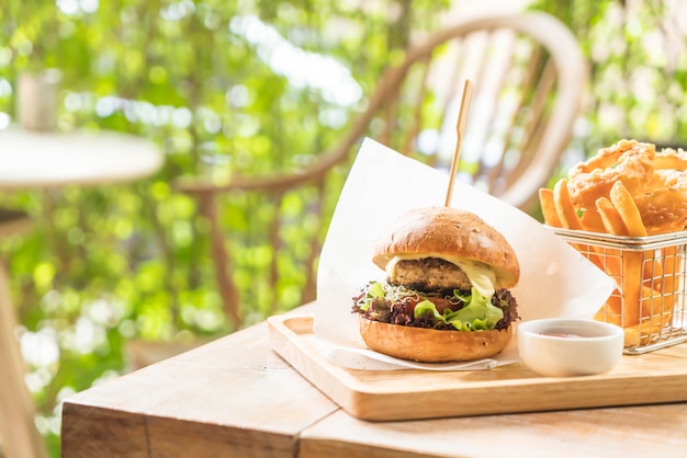 pork burger with onion rings and french fries