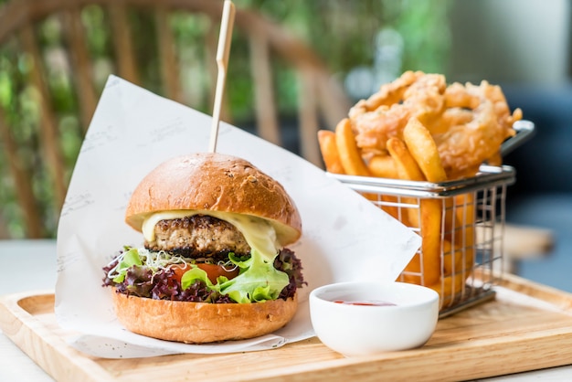 pork burger with onion rings and french fries