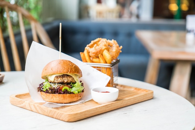 Hamburger di maiale con anelli di cipolla e patate fritte