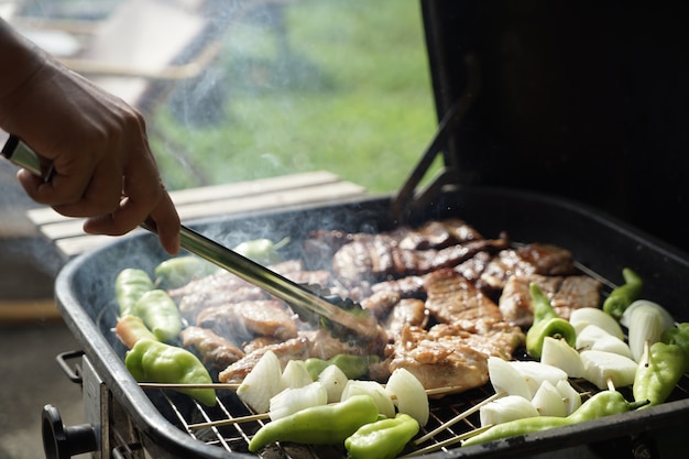 バーベキュー料理ディナーをするグリルの豚肉と鶏のロースト