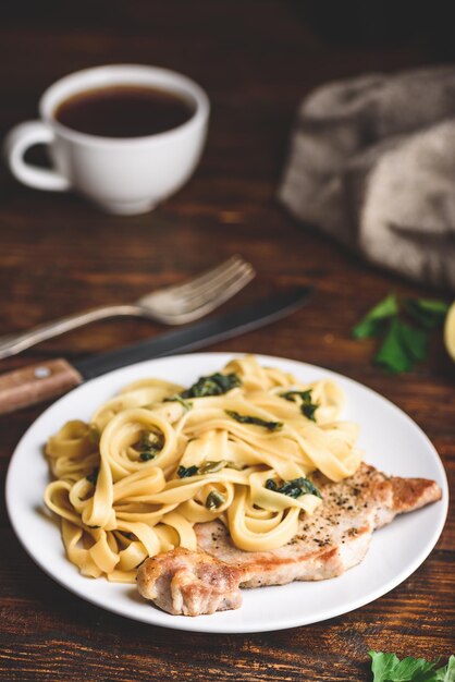 Foto bistecca di braciola di maiale con tagliatelle e capperi