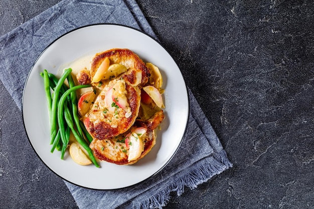 Pork chops in apple cider cream sauce on a plate