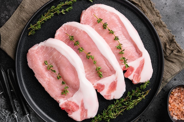 Photo pork chops set, on black dark stone table background, top view flat lay