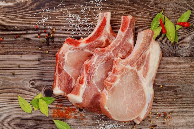 Pork cut meat chop with bay leaf and red pepper. Close up.