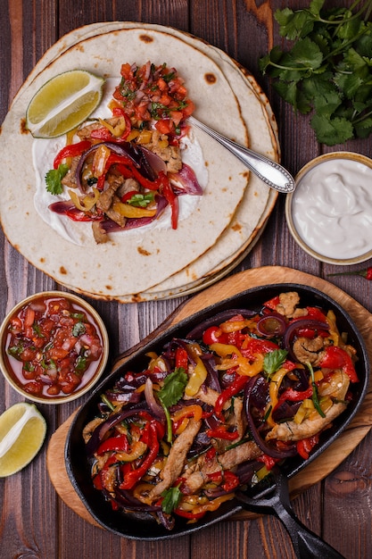 Pork fajitas with onions and colored pepper, served with tortillas,salsa and sour cream.