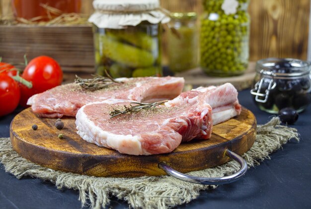 Foto costolette di filetto di maiale su un tagliere di legno.