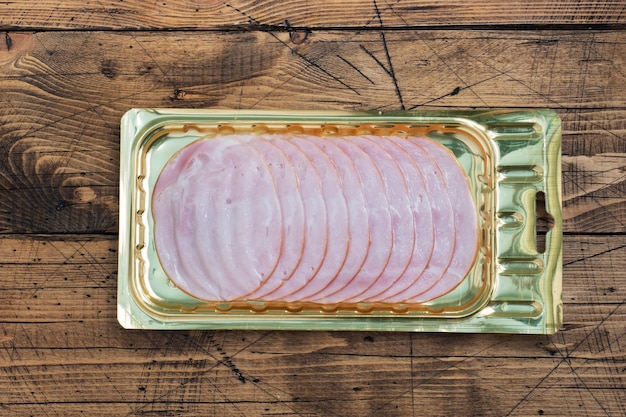 Pork ham in thin slices in a vacuum package on the table meat\
sliced carbonate in a package for longterm storage