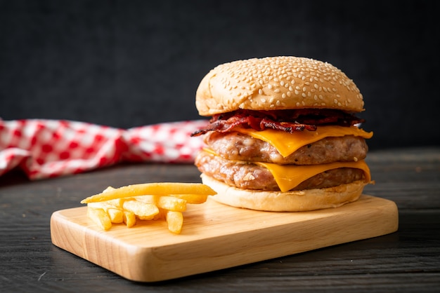 Foto hamburger di maiale con formaggio, bacon e patatine fritte