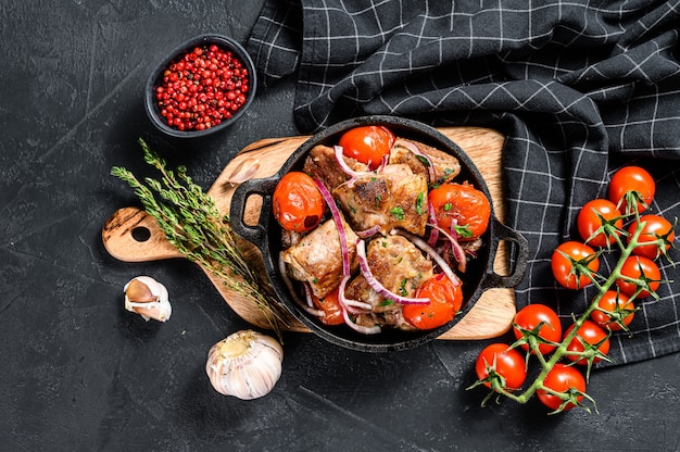 Pork kebab with tomato and pepper in a pan