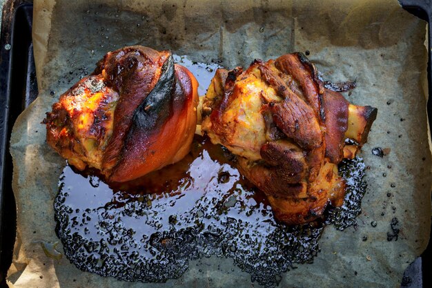 Foto gnuccolo di maiale gnuclo di maiale arrostito cotto nel forno su carta pergamena grandi porzioni di cibo in natura closeup