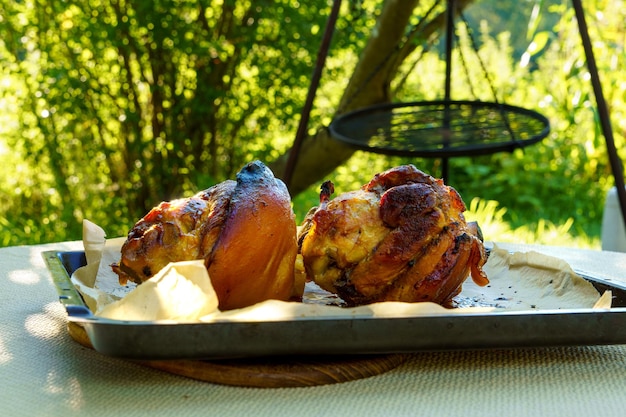 Photo pork knuckle roasted pork knuckle baked in the oven on parchment paper large portions of food in nature closeup