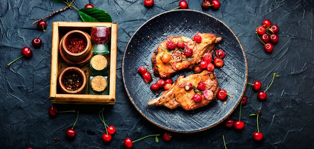 Pork meat on the bone roast in berry marinate.Grilled pork steaks in cherry wine sauce