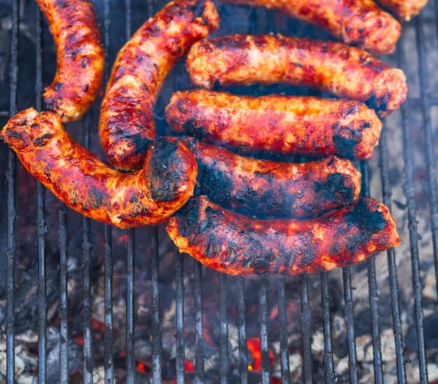 Pork meat and sausages grilled on a charcoal barbeque top view of tasty barbecue food concept food on grill and detail of food on the grill