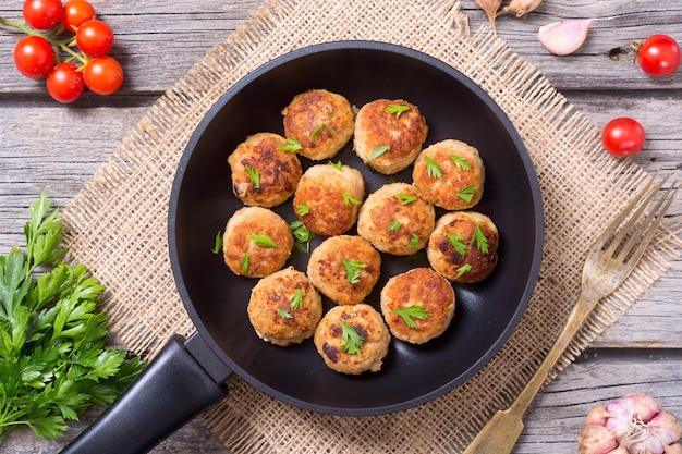 Pork meatballs with parsley in pan Top view