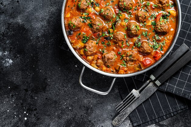 Pork meatballs with tomato sauce and vegetables in a pan