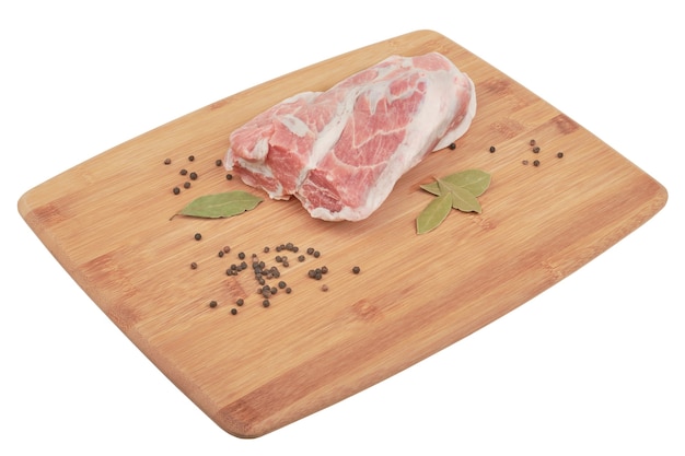 pork neck with pepper and bay leaf on a wooden board isolated on white background