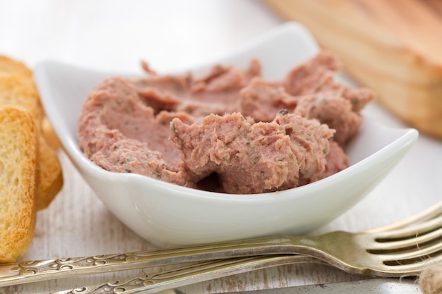 Pork pate in bowl with toasts