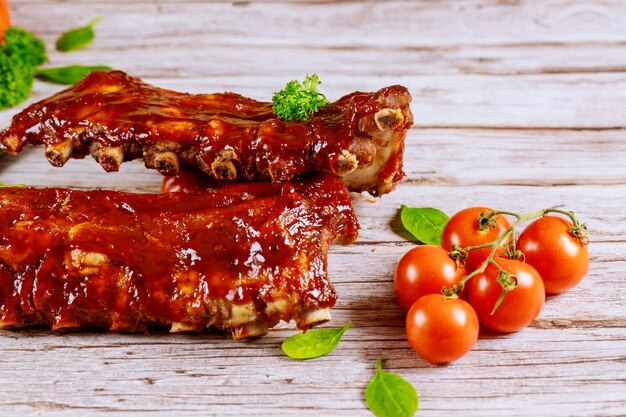 Pork ribs grilled with BBQ sauce , tomato and spinach.