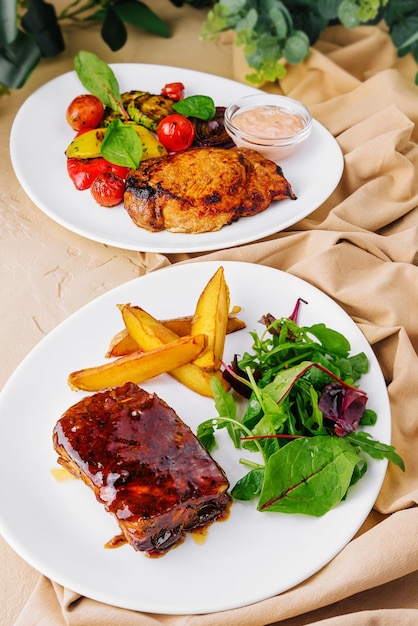 Photo pork ribs with potatoes and pork steak with grilled vegetables