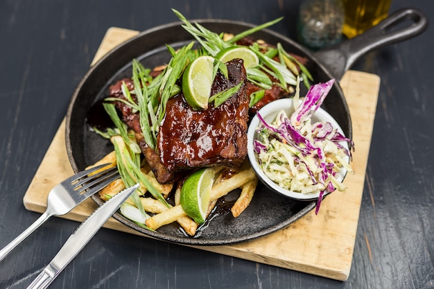 Pork ribs with vegetables on a wooden table