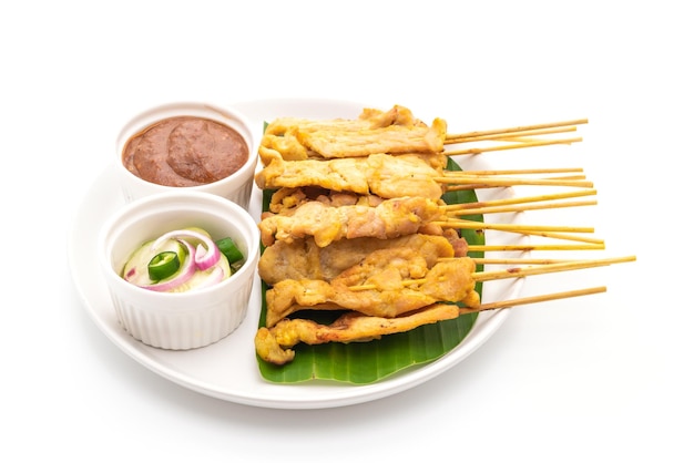 Pork satay - Grilled pork served with peanut sauce or sweet and sour sauce - isolated on white background