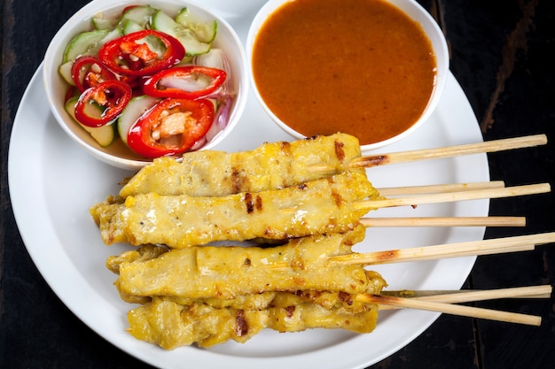 나무 테이블, 태국의 돼지 고기 Satay 길거리 음식에 소스와 함께 하얀 접시에 돼지 고기 Satay 꼬치 대나무.