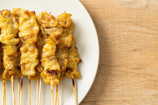 Pork satay with peanut sauce pickles which are cucumber slices and onions in vinegar - Asian food style