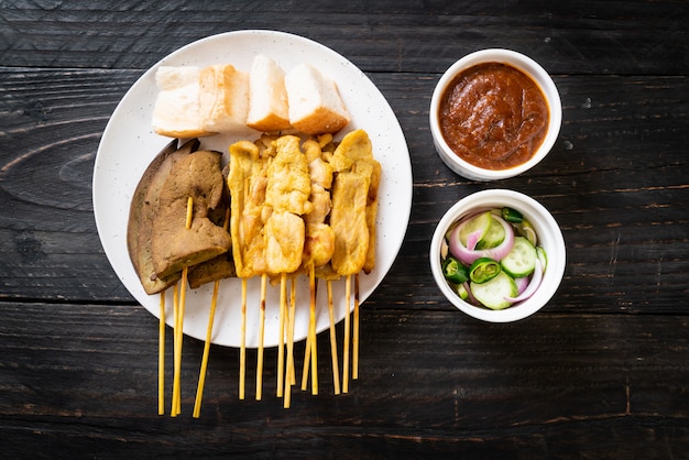Pork Satay with your Peanut Sauce  and pickles which are cucumber slices and onions in vinegar