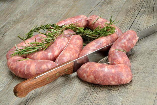 Pork sausages with herbs on wooden table