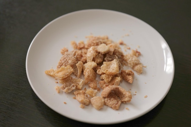 Pork scratchings or pork cracklings served in white dish