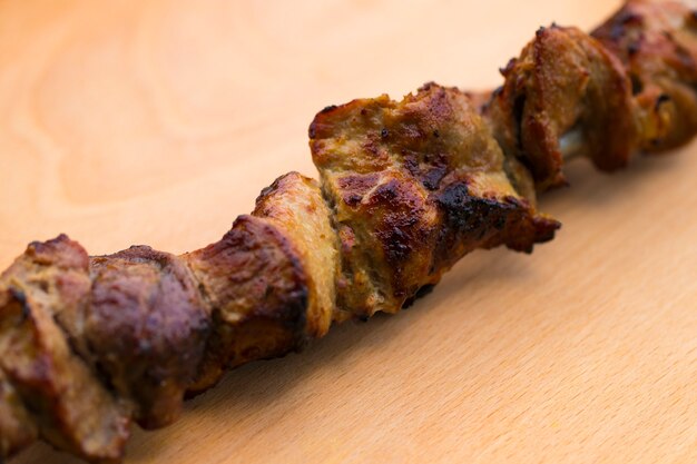 Pork shish kebab on a wooden table.