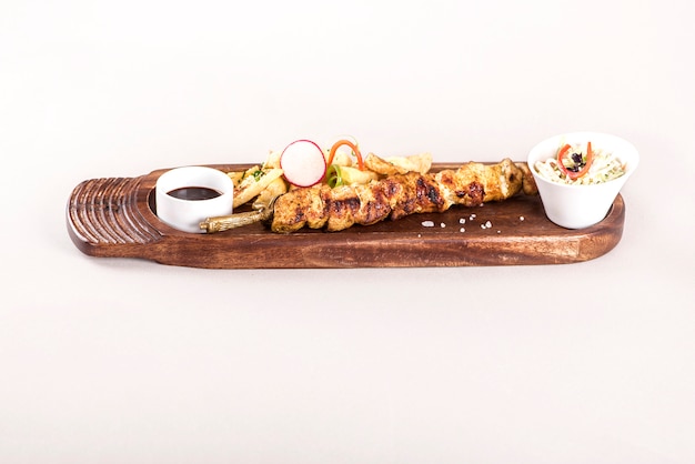 Pork skewers served with baked potatoes, Coleslaw salad and barbecue sauce